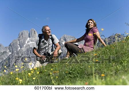 mature couple resting on meadow in the mountains View Large Photo Image Stock Image - mature couple resting on meadow in the mountains. Fotosearch