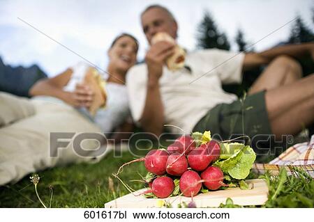 mature couple sitting on meadow in the mountains having picnic View Large Photo Image Stock Image - mature couple sitting on meadow in the mountains having picnic. Fotosearch