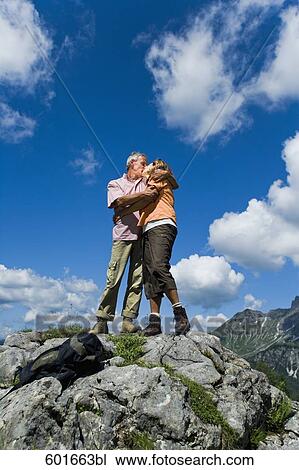 mature couple standing on rock in the mountains kissing each other View Large Photo Image Stock Image - mature couple standing on rock in the mountains kissing each other. Fotosearch