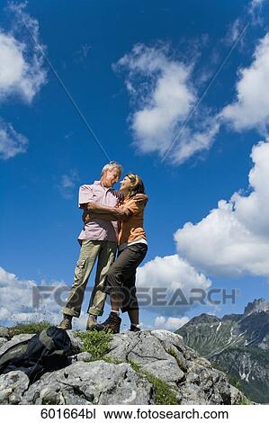 mature couple standing on rock in the mountains embracing each other View Large Photo Image Stock Image - mature couple standing on rock in the mountains embracing each other. Fotosearch