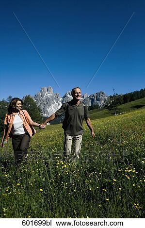 mature couple walking hand in hand in the mountains View Large Photo Image Stock Image - mature couple walking hand in hand in the mountains. Fotosearch
