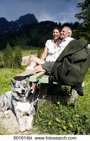 mature couple with dog sitting on bench in the mountains View Large Photo Image Stock Image - mature couple with dog sitting on bench in the mountains. Fotosearch