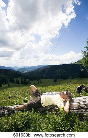mature man dozing on log in the mountains View Large Photo Image Stock Image - mature man dozing on log in the mountains. Fotosearch
