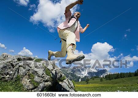 mature man jumping from rock in the mountains View Large Photo Image Stock Image - mature man jumping from rock in the mountains. Fotosearch