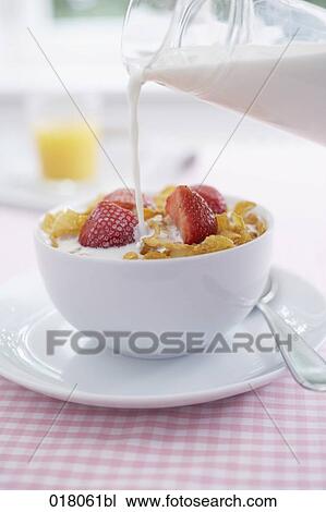 Stock Image - milk being poured onto cereals. Fotosearch