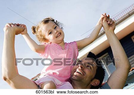 Stock Image - portrait of father carrying little girl on his shoulders. Fotosearch