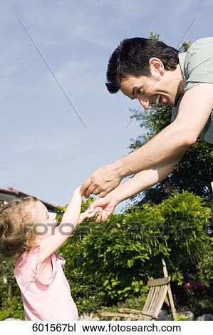 portrait of father dancing with little girl in garden View Large Photo Image Stock Image - portrait of father dancing with little girl in garden. Fotosearch