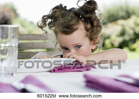portrait of little girl sitting at table in garden View Large Photo Image Stock Image - portrait of little girl sitting at table in garden. Fotosearch
