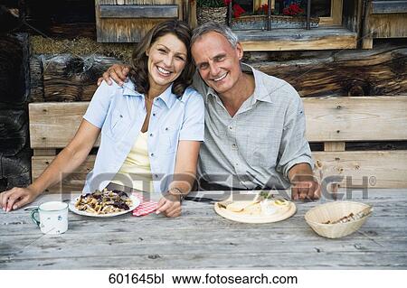 portrait of mature couple having meal in front of alpine hut View Large Photo Image Stock Image - portrait of mature couple having meal in front of alpine hut. Fotosearch