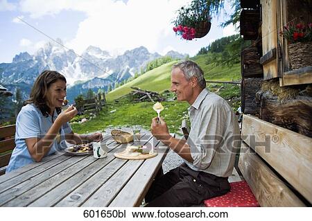 Stock Image - portrait of mature couple having meal in the mountains. Fotosearch