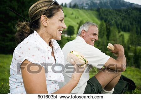 Stock Image - portrait of mature couple having picnic in the mountains. Fotosearch