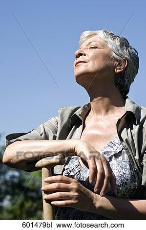 portrait of mature woman in garden enjoying the summer sun View Large Photo Image Stock Image - portrait of mature woman in garden enjoying the summer sun. Fotosearch