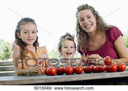 portrait of mother with her two daughters sitting at table in garden View Large Photo Image Stock Image - portrait of mother with her two daughters sitting at table in garden. Fotosearch
