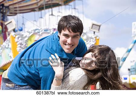 portrait of teenage couple embracing at fun fair View Large Photo Image Stock Image - portrait of teenage couple embracing at fun fair. Fotosearch