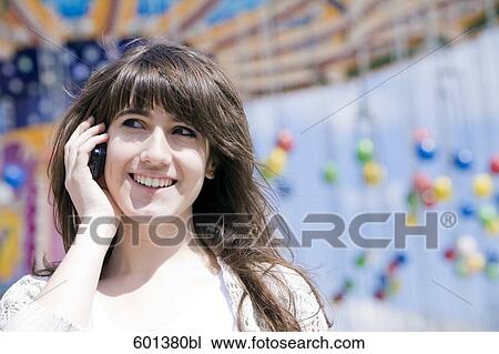 portrait of teenage girl fair talking on mobile phone at fun fair View Large Photo Image Stock Image - portrait of teenage girl fair talking on mobile phone at fun fair. Fotosearch