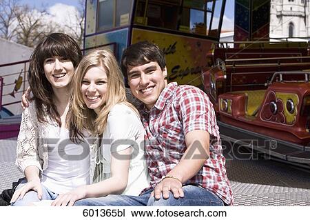 portrait of three teenage friends sitting at merry-go-round View Large Photo Image Stock Image - portrait of three teenage friends sitting at merry-go-round. Fotosearch