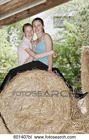 portrait of two friends sitting on hay bale View Large Photo Image Stock Image - portrait of two friends sitting on hay bale. Fotosearch
