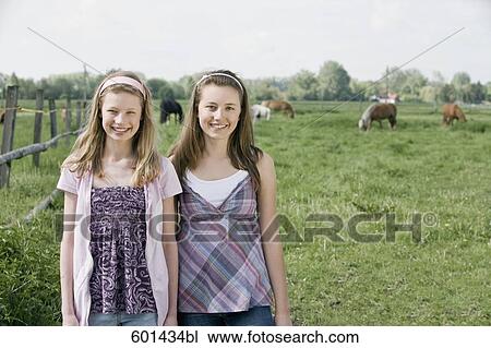 Stock Image - portrait of two girls on horse ranch. Fotosearch