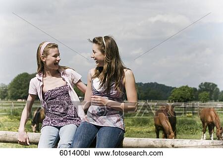 portrait of two girls sharing a laugh on horse ranch View Large Photo Image Stock Image - portrait of two girls sharing a laugh on horse ranch. Fotosearch