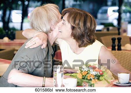 portrait of two senior women in cafe embracing each other View Large Photo Image Stock Image - portrait of two senior women in cafe embracing each other. Fotosearch