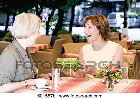 portrait of two senior women in cafe one receiving present View Large Photo Image Stock Image - portrait of two senior women in cafe one receiving present. Fotosearch
