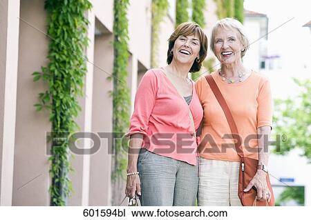 Stock Image - portrait of two senior women with shopping bags. Fotosearch
