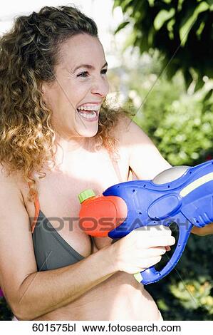 portrait of woman playing with water pistol View Large Photo Image Stock Image - portrait of woman playing with water pistol. Fotosearch