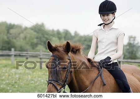 portrait of young girl doing horseback riding View Large Photo Image Stock Image - portrait of young girl doing horseback riding. Fotosearch
