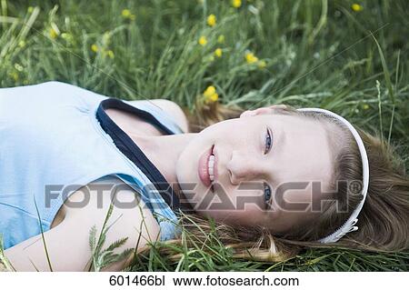 portrait of young girl lying in grass View Large Photo Image Stock Image - portrait of young girl lying in grass. Fotosearch