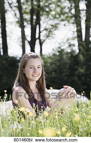 portrait of young girl sitting on meadow View Large Photo Image Stock Image - portrait of young girl sitting on meadow. Fotosearch