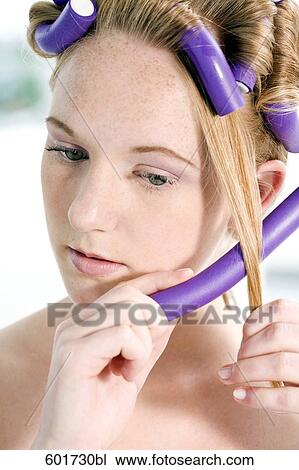 portrait of young woman putting curlers in her hair View Large Photo Image Stock Image - portrait of young woman putting curlers in her hair. Fotosearch