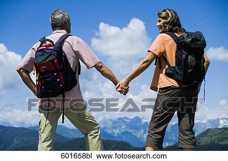 rear view of mature couple in the mountains holding hands View Large Photo Image Stock Image - rear view of mature couple in the mountains holding hands. Fotosearch