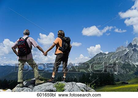 rear view of mature couple in the mountains holding hands View Large Photo Image Stock Image - rear view of mature couple in the mountains holding hands. Fotosearch