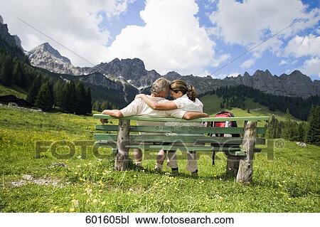 rear view of mature couple sitting on bench in front of mountains View Large Photo Image Stock Image - rear view of mature couple sitting on bench in front of mountains. Fotosearch