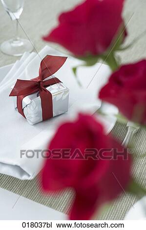 Stock Image - still life of gift box on place setting. Fotosearch