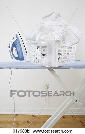 still life of ironing board with flat iron and pile of laundry in basket View Large Photo Image Stock Image - still life of ironing board with flat iron and pile of laundry in basket. Fotosearch