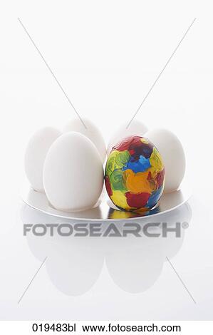 Stock Image - still life of six eggs on a plate one painted. Fotosearch