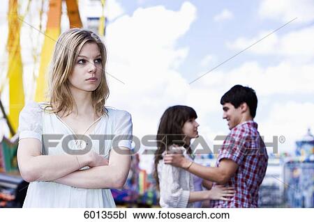 sulking teenage girl at fun fair with couple in background View Large Photo Image Stock Image - sulking teenage girl at fun fair with couple in background. Fotosearch