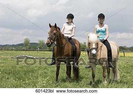 two girls doing horseback riding View Large Photo Image Stock Image - two girls doing horseback riding. Fotosearch