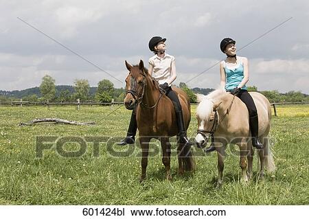 two girls doing horseback riding View Large Photo Image Stock Image - two girls doing horseback riding. Fotosearch