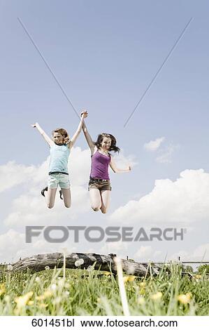 two girls jumping up in the air View Large Photo Image Stock Image - two girls jumping up in the air. Fotosearch