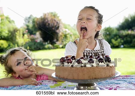 two young girls tasting cream cake View Large Photo Image Stock Image - two young girls tasting cream cake. Fotosearch