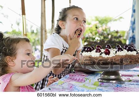 two young girls tasting cream cake View Large Photo Image Stock Image - two young girls tasting cream cake. Fotosearch