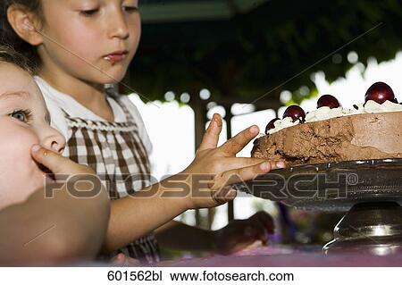 two young girls tasting cream cake View Large Photo Image Stock Image - two young girls tasting cream cake. Fotosearch
