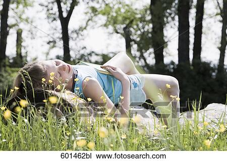 young girl taking a nap on a tree trunk in the countryside View Large Photo Image Stock Image - young girl taking a nap on a tree trunk in the countryside. Fotosearch
