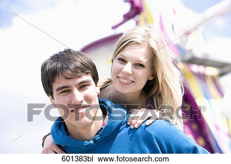 young man giving girlfriend piggyback ride at fun fair View Large Photo Image Stock Image - young man giving girlfriend piggyback ride at fun fair. Fotosearch