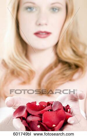 young woman holding red petals in her hands View Large Photo Image Stock Image - young woman holding red petals in her hands. Fotosearch