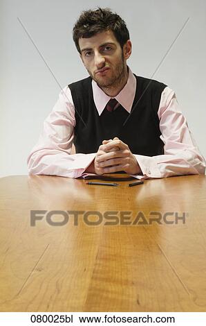 annoyed businessman sitting at conference table View Large Photo Image Stock Image - annoyed businessman sitting at conference table. Fotosearch