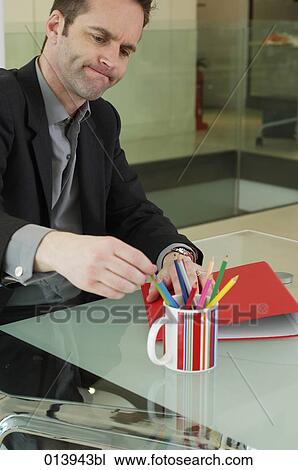 annoyed looking employee taking pencil from cup on table View Large Photo Image Stock Image - annoyed looking employee taking pencil from cup on table. Fotosearch