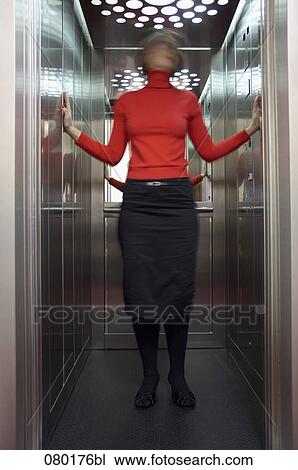 Stock Image - blurred portrait of businesswoman standing in elevator. Fotosearch
